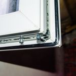 Atverto plastikinio lango varčios kampas, tarpinė ir metalinė furnitūra